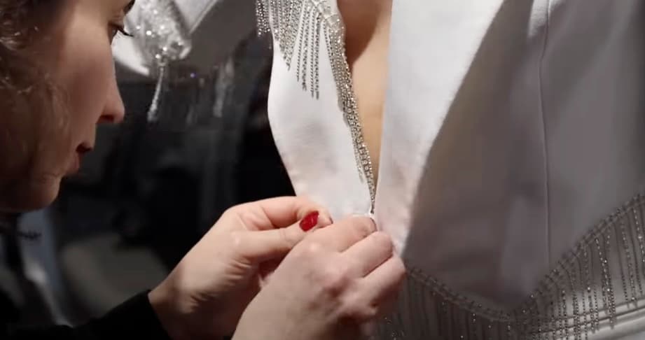 Woman adjusting a model's clothing