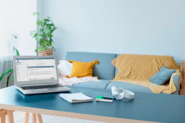 Table in a living room with a laptop, headset, pens, and a notebook on top