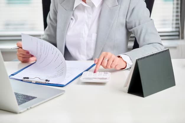 Woman in coat with documents, typing on calculator