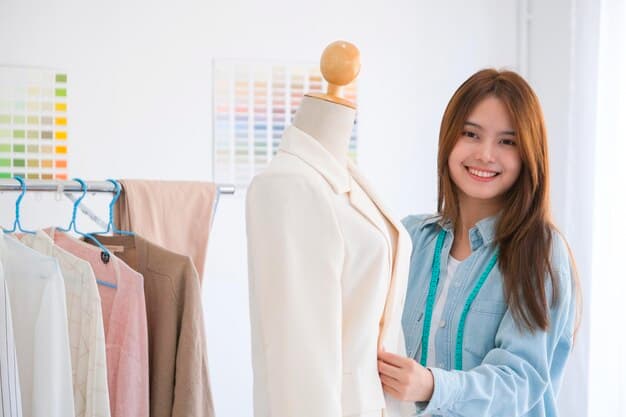A fashion designer holding a mannequin and looking at the camera