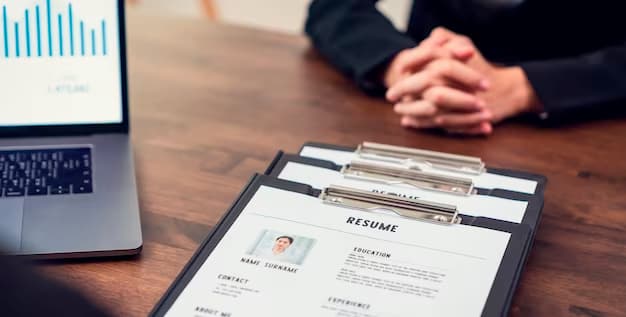 Table with resumes and a laptop